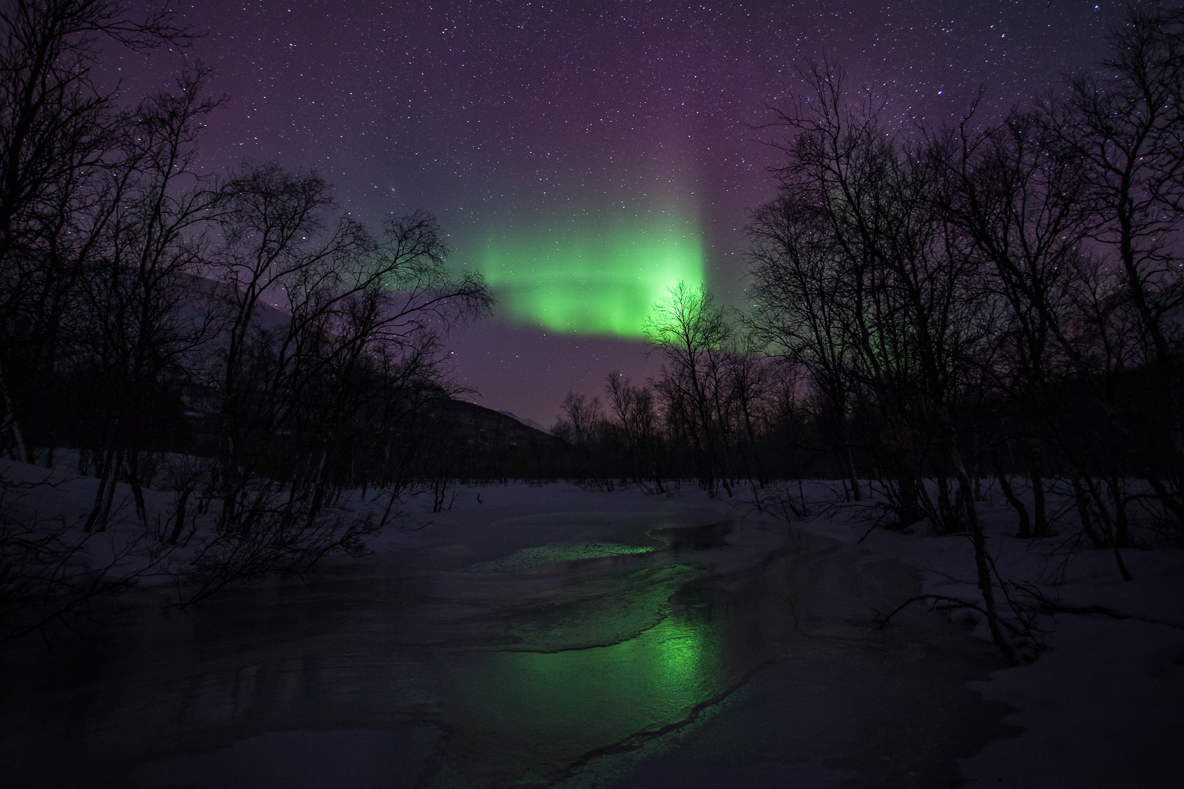 Voyage photo aurores boréales en Laponie, aurores sur une rivière gelée dans les Alpes de Lyngen, en Norvège