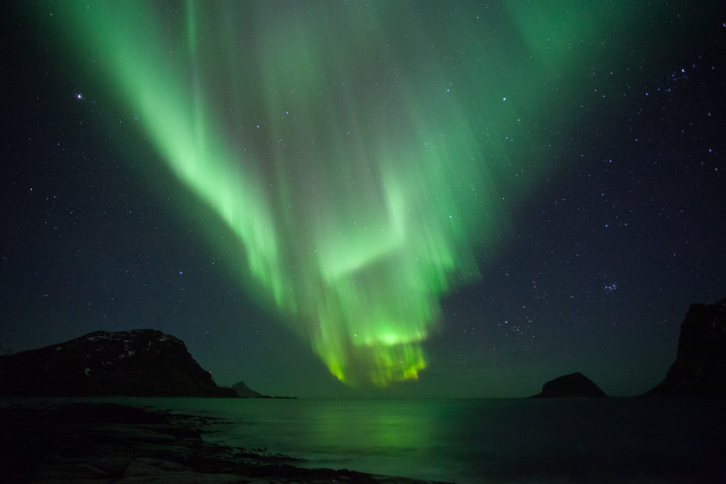 grande aurore boréale à la plage d'Haukland, en voyage photo aux Lofoten